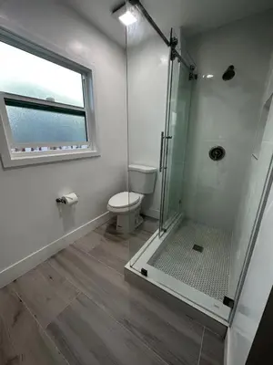 a bathroom with a shower with a toilet and a window at Gated & Morden 1bed1bath house3367 in Baldwin Park