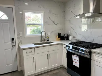 a kitchen with white cabinets and a stove and a sink at Fully remoded 1B1B Home in baldwin Park3369A in Baldwin Park
