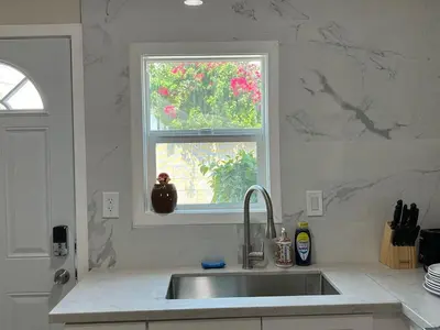 a kitchen with a sink and a window with pink flowers at Fully remoded 1B1B Home in baldwin Park3369A in Baldwin Park