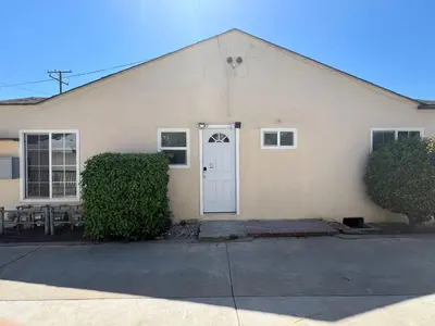 a white building with a white door and two bushes at Fully remoded 1B1B Home in baldwin Park3369A in Baldwin Park