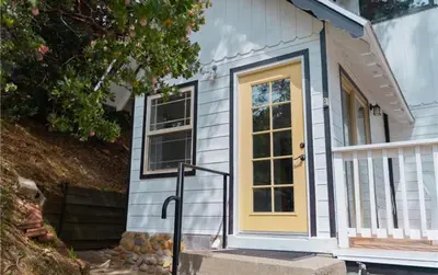 a small tiny house with a yellow door at Cozy Crestline Cabin Getaway in Crestline