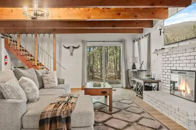 a living room with a couch and a fireplace at Cowboy Cabin with Lake Views in Big Bear Lake