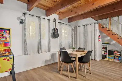 a dining room with a table and chairs and a guitar at Cowboy Cabin with Lake Views in Big Bear Lake