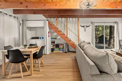 a living room with a couch and a table at Cowboy Cabin with Lake Views in Big Bear Lake