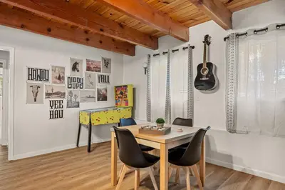 a dining room with a table and a guitar on the wall at Cowboy Cabin with Lake Views in Big Bear Lake
