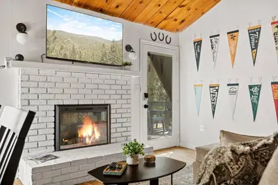 a fireplace in a living room with a fire place at Cowboy Cabin with Lake Views in Big Bear Lake