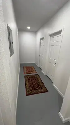 an empty hallway with two doors and two rugs at Naryn Guest house in Los Angeles