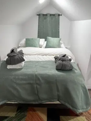 a bedroom with two beds with green and white at Naryn Guest house in Los Angeles