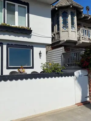 a white fence in front of a house at Manhattan Beach Beachfront Charming On The Strand in Manhattan Beach