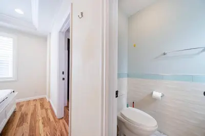 a white bathroom with a toilet and a shower at 40 ppl 2 houses 13 Bedrooms btw Disney Hollywd in Monterey Park