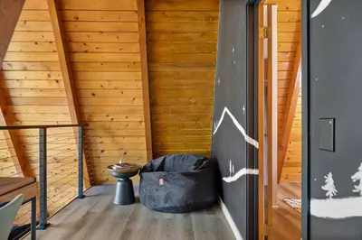 a room with wooden walls and wooden flooring and a staircase at Midnight Chalet Big Bear Lake in Big Bear Lake