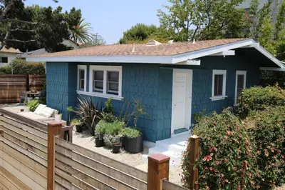 a blue tiny house with a wooden fence at Bougainvillea Bungalow Peaceful Venice Retreat in Los Angeles