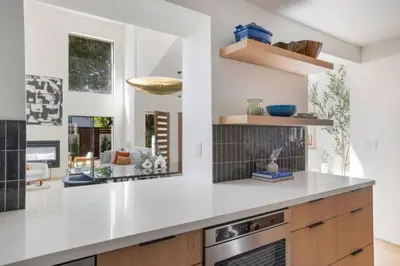 a kitchen with white countertops and a living room at Pacific Breeze - Modern Venice Beach Home in Los Angeles
