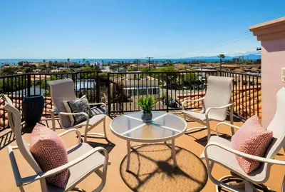 a patio with chairs and a table on a balcony at Oceanview Coastal Retreat in Redondo Beach in Redondo Beach