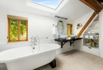 a bathroom with a large tub and two sinks at Retreat to the Rocks Historic Film And Music Getaway in Chatsworth Lake Manor