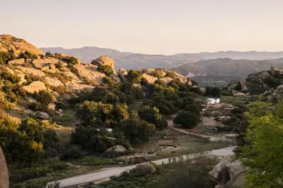 a road in the mountains with trees and rocks at Retreat to the Rocks Historic Film And Music Getaway in Chatsworth Lake Manor
