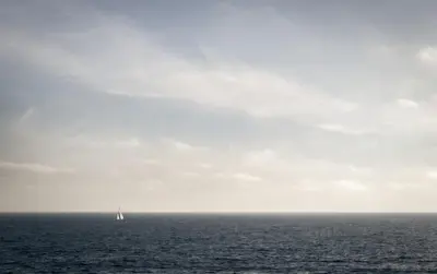 a sail boat in the ocean on a cloudy day at New The Triton Manhattan Beachfront Escape in Manhattan Beach