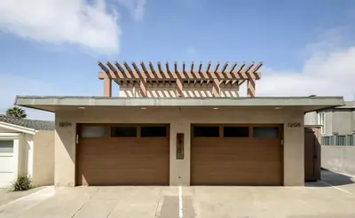 a house with two garage doors in a driveway at New The Triton Manhattan Beachfront Escape in Manhattan Beach