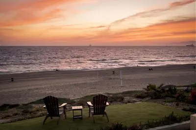 two chairs sitting on the beach at sunset at New The Triton Manhattan Beachfront Escape in Manhattan Beach