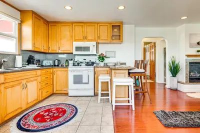 a kitchen with wooden cabinets and white appliances at Steps to Ocean Manhattan Beach Gem with Deck! in Manhattan Beach