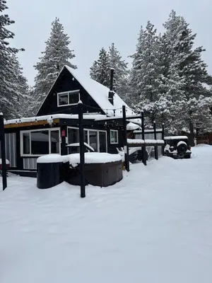 a house with snow on the ground in front of it at The Honey Bear Cabin Jacuzzi EV Friendly Renovated in Green Valley Lake