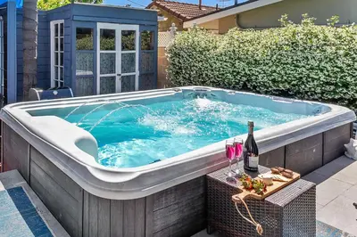 a hot tub in a backyard with a bottle of wine at Spa, Parking, King Bd, Desk, 7 Min Walk to Beach in Long Beach