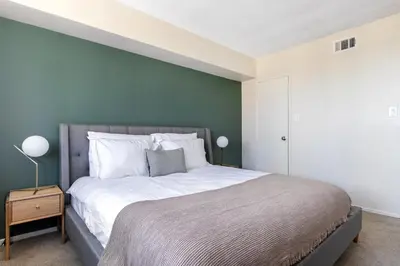 a bedroom with a large bed with a green accent wall at Brentwood 2BR w Outdoor Pool nr shops LAX-146 in Los Angeles