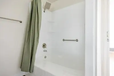 a shower with a green shower curtain in a bathroom at Blueground Venice pool wd nr beach LAX-1329 in Los Angeles