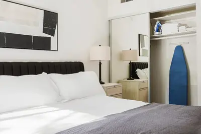 a bedroom with a white bed and a mirror at Blueground Burbank pool bbq nr studios LAX-1321 in Los Angeles