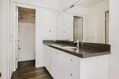 a white bathroom with a sink and a mirror at Blueground Burbank pool bbq nr studios LAX-1321 in Los Angeles