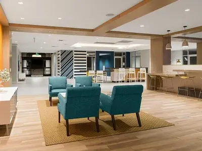 a lobby with blue chairs and a kitchen in a building at Blueground Burbank pool bbq nr studios LAX-1321 in Los Angeles