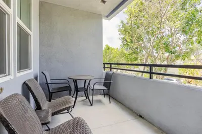 a balcony with chairs and a table and a window at Blueground Playa Vista pool AC nr beach LAX-1353 in Los Angeles