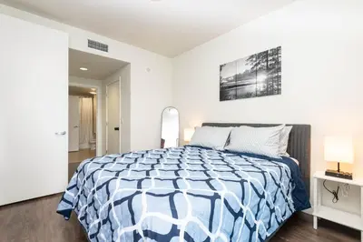 a bedroom with a bed with a blue and white comforter at Vista Point Suites in Los Angeles