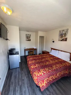 a hotel room with a bed and a television at World Motel in Lynwood