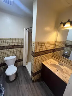 a bathroom with a toilet and a sink at World Motel in Lynwood