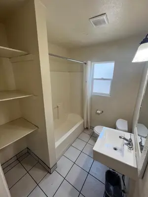 a bathroom with a shower and a sink and a tub at World Motel in Lynwood