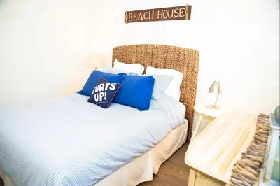 a bedroom with a bed with blue pillows on it at 4980 Sandyland Road #216 in Carpinteria