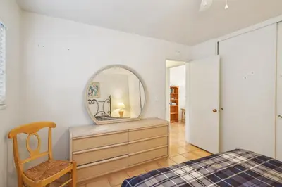 a bedroom with a mirror and a dresser with a chair at 4950 Sandyland Road #127 condo in Carpinteria