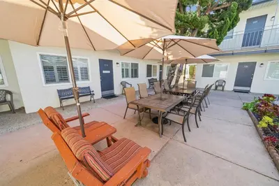 a patio with a table and chairs and umbrellas at Beach Condo with Private Patio #133 in Carpinteria
