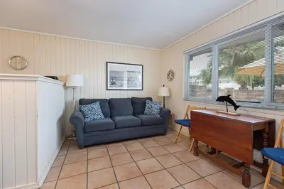 a living room with a couch and a piano at Beach Condo with Private Patio #133 in Carpinteria