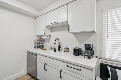 a kitchen with white cabinets and a sink at 2 Bed Beach Condo #125 in Carpinteria