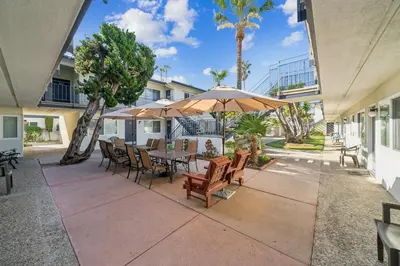 a patio with a table and chairs and umbrellas at 2 Bed Beach Condo #125 in Carpinteria