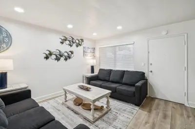 a living room with two couches and a table at 2 Bed Beach Condo #125 in Carpinteria