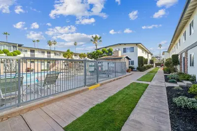 a balcony with a fence and a swimming pool at Beach Condo with Private Patio #135 in Carpinteria