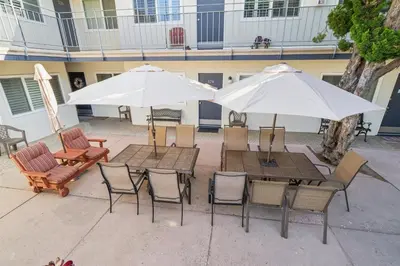 an outdoor patio with tables and chairs and umbrellas at Beach Condo with Private Patio #135 in Carpinteria