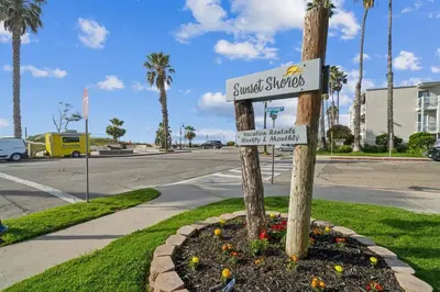 a street sign on a pole in a flower bed at Beautiful 1 Bed Beach Balcony Condo #207 in Carpinteria