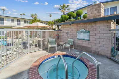 a swimming pool with a patio with chairs and a table at Beautiful 1 Bed Beach Balcony Condo #207 in Carpinteria