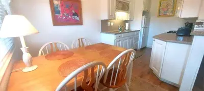 a kitchen with a wooden table with chairs and a dining room at Full 1 Bed Beach Condo #227 in Carpinteria