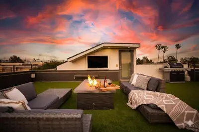 a patio with couches and a fire pit on the grass at NEW Modern Oasis off Melrose - Rooftop - Pool in Los Angeles