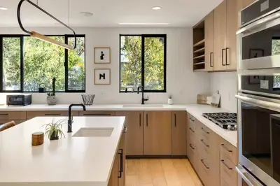 a kitchen with white counter tops and windows at Hollywood Hills Villa by Universal - Pool - Dogs OK in Los Angeles